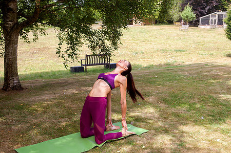 simsearch:649-09195584,k - Woman practicing yoga in garden, bending over backwards Photographie de stock - Premium Libres de Droits, Code: 649-09195579