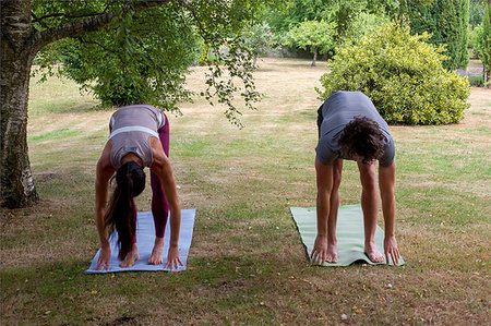 simsearch:649-09257990,k - Man and woman practicing yoga in garden, bending forward Foto de stock - Sin royalties Premium, Código: 649-09195572