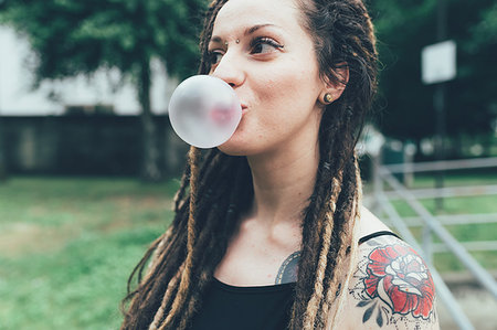 simsearch:649-09195670,k - Woman blowing bubble gum in park Stock Photo - Premium Royalty-Free, Code: 649-09195674