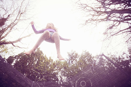 Girl jumping on trampoline, low angle view Stock Photo - Premium Royalty-Free, Code: 649-09195871