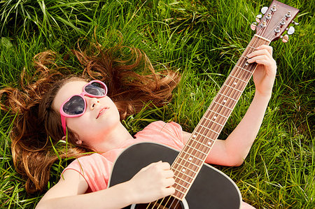 simsearch:614-00658816,k - Girl playing guitar on grass Photographie de stock - Premium Libres de Droits, Code: 649-09195888