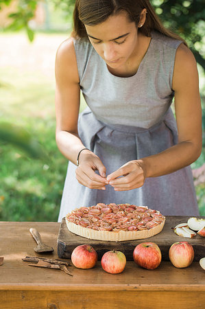 preparation of apple pie - Woman preparing apple pie on table Stock Photo - Premium Royalty-Free, Code: 649-09195947