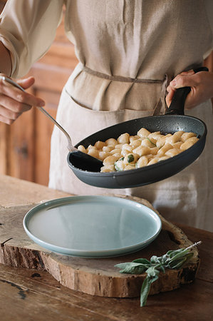 Potato gnocchi in frying pan being served Stock Photo - Premium Royalty-Free, Code: 649-09195976