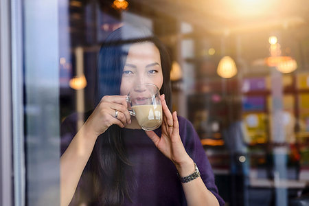 Mid adult woman drinking coffee in cafe window seat, portrait Stock Photo - Premium Royalty-Free, Code: 649-09196522