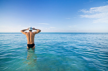 simsearch:6118-08399557,k - Man preparing for swim in tropical sea Photographie de stock - Premium Libres de Droits, Code: 649-09205606