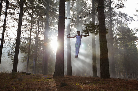 flying trapeze - Gymnast using rings in forest Stock Photo - Premium Royalty-Free, Code: 649-09205746