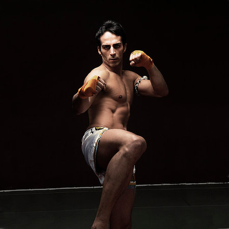 simsearch:632-06317467,k - Boxer kicking with raised fists Photographie de stock - Premium Libres de Droits, Code: 649-09206107