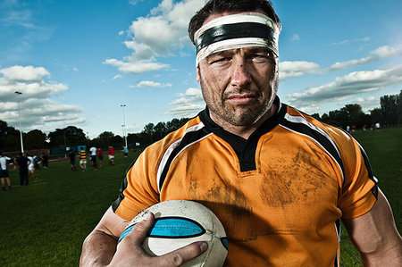 Rugby player holding ball on pitch, portrait Stock Photo - Premium Royalty-Free, Code: 649-09206886