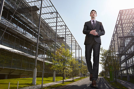 simsearch:614-08875291,k - Oversized businessman walking on road, low angle view Photographie de stock - Premium Libres de Droits, Code: 649-09207099