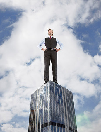 simsearch:614-08875291,k - Oversized businessman standing on skyscraper, low angle view Photographie de stock - Premium Libres de Droits, Code: 649-09207102