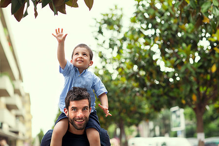 reaching for leaves - Father carrying son on shoulders Stock Photo - Premium Royalty-Free, Code: 649-09207172
