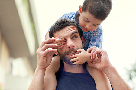 Father carrying son on shoulders, boy covering man's eye Stock Photo - Premium Royalty-Free, Code: 649-09207173