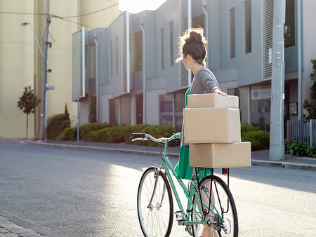 simsearch:400-04748524,k - Young woman pushing bicycle with cardboard boxes Stock Photo - Premium Royalty-Free, Code: 649-09207694