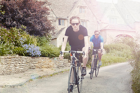 simsearch:649-09207895,k - Cyclists riding through village, Cotswolds, UK Foto de stock - Royalty Free Premium, Número: 649-09207878
