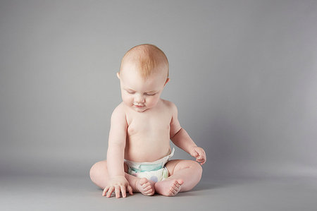 Studio portrait of baby boy sitting up and touching floor Photographie de stock - Premium Libres de Droits, Code: 649-09207901