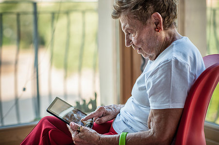 A very senior woman using touchscreen on digital tablet on apartment balcony Stock Photo - Premium Royalty-Free, Code: 649-09207942