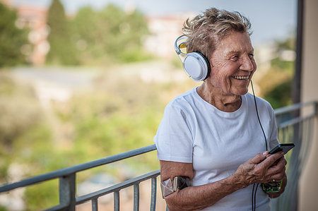 simsearch:649-08544187,k - A very senior woman listening to music on headphones on apartment balcony Foto de stock - Sin royalties Premium, Código: 649-09207943