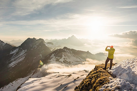 simsearch:649-09208194,k - Young male mountain trekker photographing view of clouds, Bavarian Alps, Oberstdorf, Bavaria, Germany Photographie de stock - Premium Libres de Droits, Code: 649-09208189