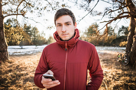 simsearch:649-08422994,k - Young male hiker using smartphone in lakeside forest Photographie de stock - Premium Libres de Droits, Code: 649-09208392