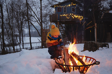 Young boy sitting by fire in snowy landscape Stockbilder - Premium RF Lizenzfrei, Bildnummer: 649-09208417