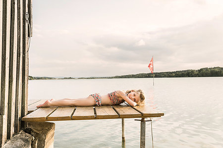 simsearch:649-08084693,k - Portrait of girl wearing bikini lying on lake pier, Munich, Bavaria, Germany Foto de stock - Royalty Free Premium, Número: 649-09208458