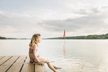 simsearch:649-06433316,k - Girl wearing bikini sitting on lake pier, Munich, Bavaria, Germany Stock Photo - Premium Royalty-Free, Code: 649-09208459