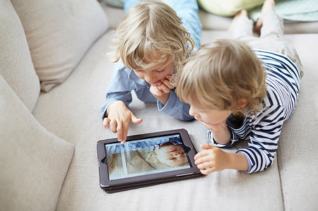 simsearch:614-06442827,k - Two boys lying on fronts side by side on sofa using digital tablet Stock Photo - Premium Royalty-Free, Code: 649-09208789