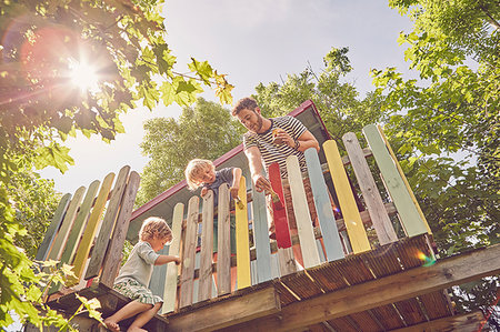 Father and two sons, painting tree house, low angle view Stock Photo - Premium Royalty-Free, Code: 649-09208834
