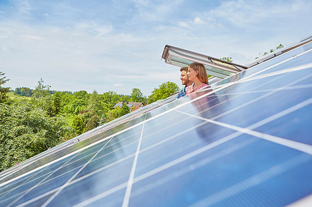 escape - Young couple looking out of window of solar panelled roof Stock Photo - Premium Royalty-Free, Code: 649-09208830