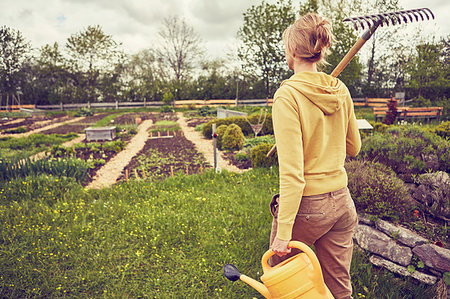 simsearch:649-09208838,k - Mature woman, gardening, carrying rake and watering can, rear view Stock Photo - Premium Royalty-Free, Code: 649-09208840
