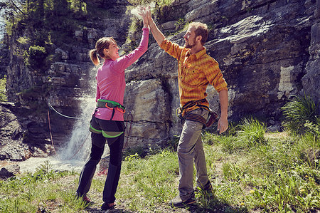 ehrwald - Climbers giving high five, waterfall in background, Ehrwald, Tyrol, Austria Stock Photo - Premium Royalty-Free, Code: 649-09208899