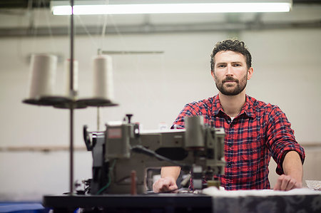 Portrait of male textile designer using sewing machine in old textile mill Stock Photo - Premium Royalty-Free, Code: 649-09208919