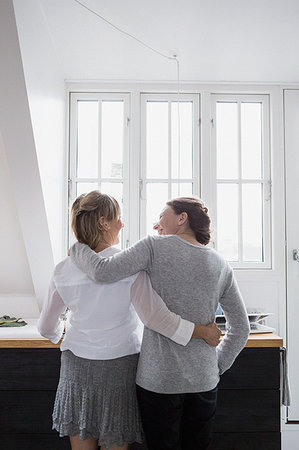 Two mature women, standing in kitchen, hugging, rear view Stock Photo - Premium Royalty-Free, Code: 649-09209246