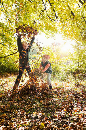 simsearch:649-08562563,k - Children playing, arms raised, throwing autumn leaves Foto de stock - Sin royalties Premium, Código: 649-09209298