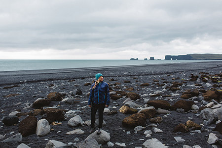 simsearch:614-08720893,k - Mid adult woman standing on rocky coastline, looking away, Iceland Stock Photo - Premium Royalty-Free, Code: 649-09209442