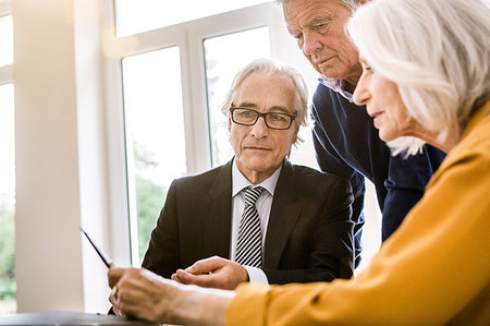 financial advisor talking to couple - Senior adults in business meeting discussing paperwork Stock Photo - Premium Royalty-Free, Code: 649-09209524