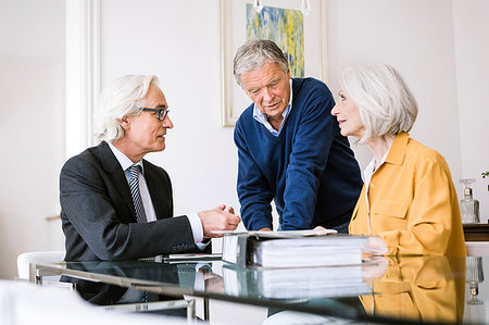 financial advisor talking to couple - Senior adults in business meeting discussing paperwork Foto de stock - Sin royalties Premium, Código: 649-09209526
