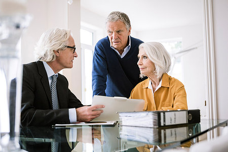 financial advisor talking to couple - Senior adults in business meeting discussing paperwork Foto de stock - Sin royalties Premium, Código: 649-09209523