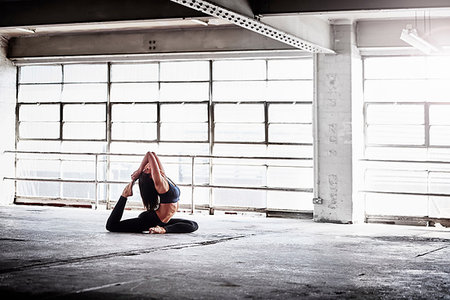 simsearch:649-08577636,k - Woman practicing yoga pose in front of warehouse window Foto de stock - Sin royalties Premium, Código: 649-09209542