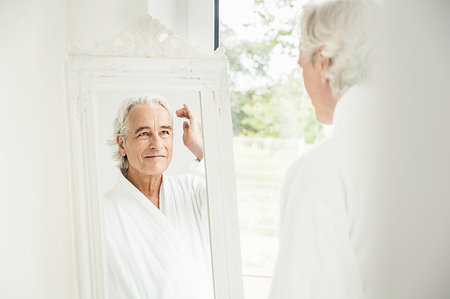 simsearch:649-07437111,k - Happy grey haired senior man wearing bathrobe looking at himself in mirror Photographie de stock - Premium Libres de Droits, Code: 649-09209604