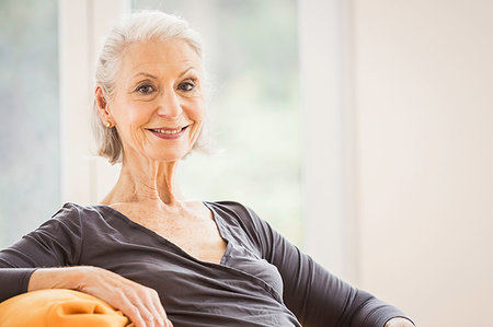 Portrait of happy senior woman on living room sofa Stock Photo - Premium Royalty-Free, Code: 649-09209627