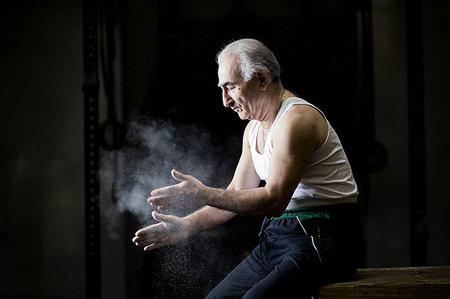 fit older black man in gym - Senior man sitting chalking hands in dark crossfit gym Stock Photo - Premium Royalty-Free, Code: 649-09209635