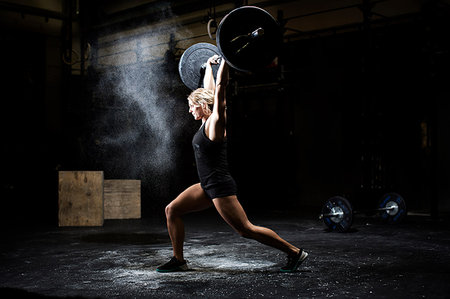 simsearch:614-09211267,k - Side view of young woman weightlifting barbell in dark crossfit gym Stockbilder - Premium RF Lizenzfrei, Bildnummer: 649-09209649