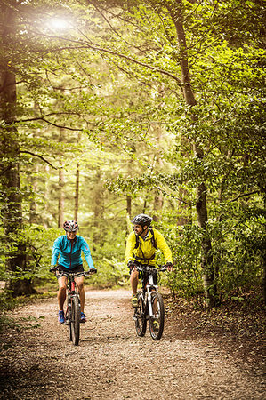 simsearch:614-08220131,k - Mature mountain biking couple chatting and cycling on forest trail Photographie de stock - Premium Libres de Droits, Code: 649-09209668