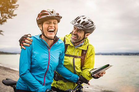 Mature mountain biking couple laughing whilst checking map at lakeside Stock Photo - Premium Royalty-Free, Code: 649-09209676