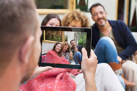 simsearch:614-08879491,k - Over the shoulder view of man photographing friends on digital tablet Stock Photo - Premium Royalty-Free, Code: 649-09209707