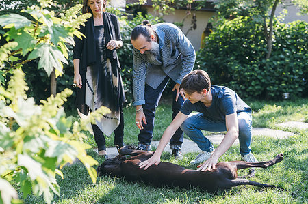 Couple with son and pet dog in garden Stock Photo - Premium Royalty-Free, Code: 649-09212701