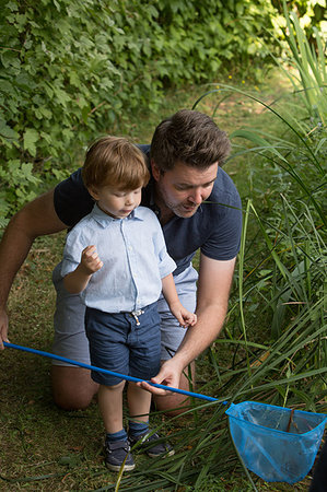 Father and child looking in fishing net Stock Photo - Premium Royalty-Free, Code: 649-09212818