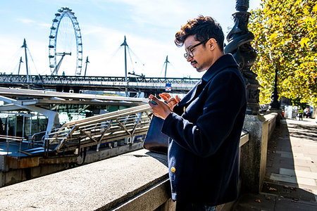 Businessman using smartphone on Embankment, London Eye and Hungerford Bridge in background, London, UK Stockbilder - Premium RF Lizenzfrei, Bildnummer: 649-09212930