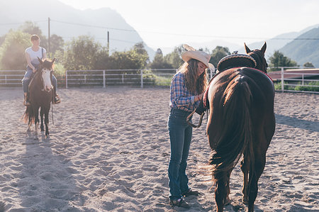 Cowgirl saddling horse in rural equestrian arena, Primaluna, Trentino-Alto Adige, Italy Foto de stock - Sin royalties Premium, Código: 649-09212954